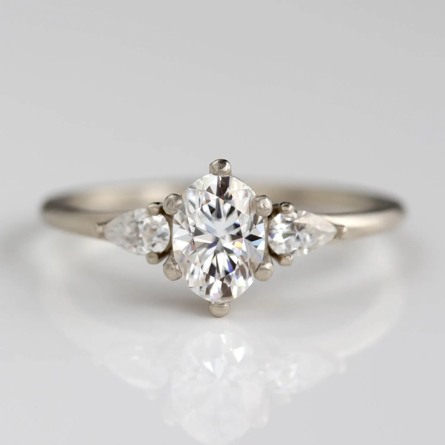 Prong-set Oval Three Stone Ring with Pear-shaped Side Stones •