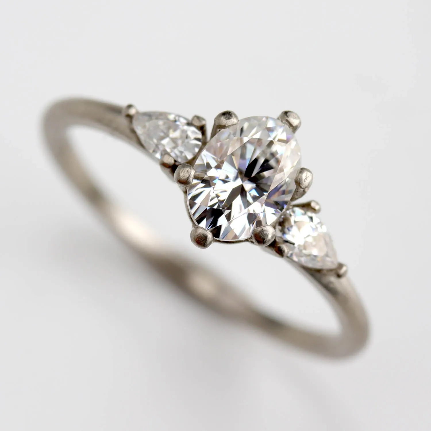 Prong-set Oval Three Stone Ring with Pear-shaped Side Stones •